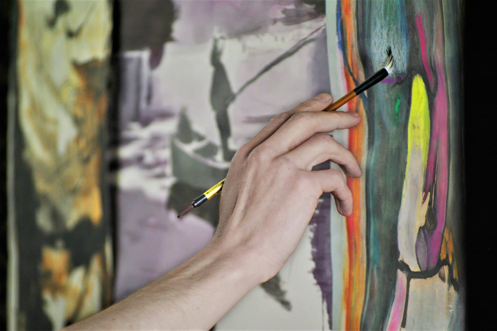 Hands painting a canvas at a Saudade art workshop